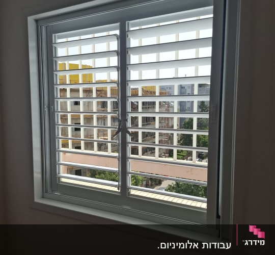 חלון אלומיניום עם תריסים נוף בניינים